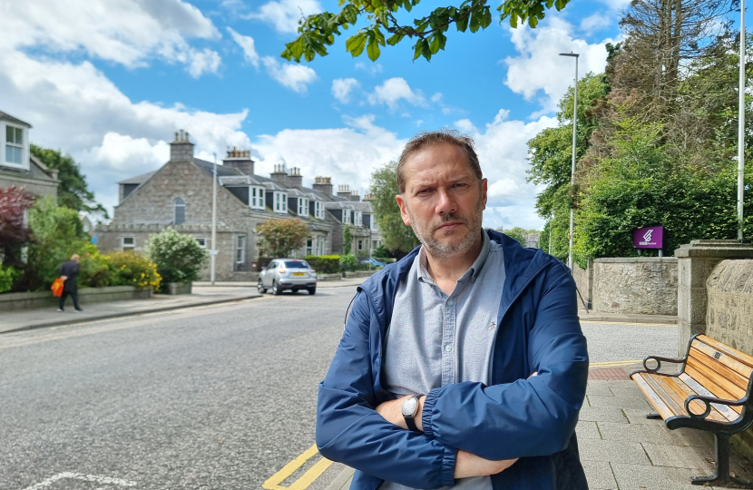 Douglas Lumsden standing beside a road in Aberdeen.