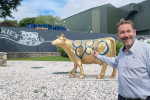 Douglas outside Mackie's of Scotland in front of their golden cow statue